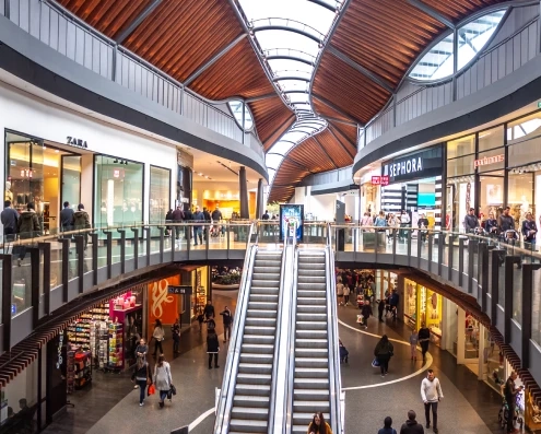 Multi-level Australian shopping centre with escalators and retail stores illustrating real-world store traffic analytics.